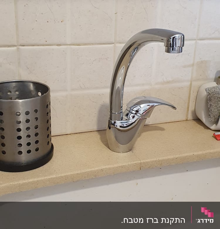 ברז כרום מעל כיור עם רשת ניקוז